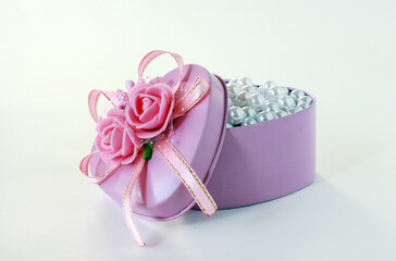 Box with flowers in the shape of a heart. Pearls in a pink box.