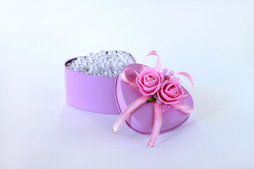 Box with flowers in the shape of a heart. Pearls in a pink box.