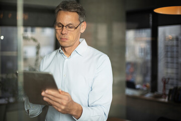 Portrait of successful businessman in office. Man writing on the glass board in office