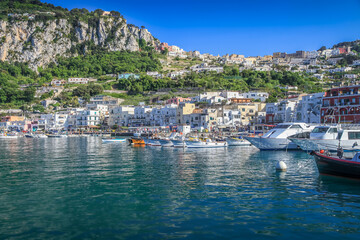 Fototapeta na wymiar Capri city cliffs and marina with boats and yacht, amalfi coast, Italy