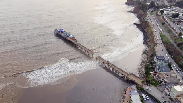 Destroyed Capitola Wharf dock after severe storm in California. Aerial view of pier with hole in the middle