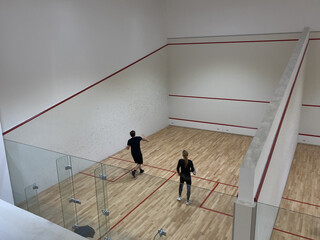 man and woman play squash match