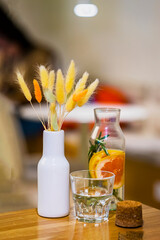 Still life. Cold Infused detox water with citrus, next to glass, bunch of dried flowers. Healthy lifestyle and diet