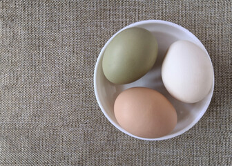 A group of chicken eggs in a white plate.