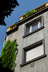 an old type house with windows and plants on it, under a blue sky on a sunny day in budapest