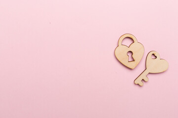 Wooden padlock with key on color background, top view