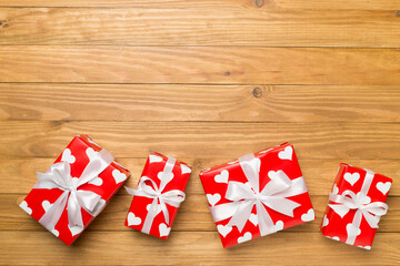 Gift boxes with hearts on wooden background, top view