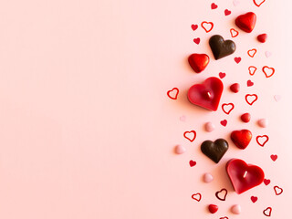 Pink valentines day background with different hearts - chocolate, candles, confetti