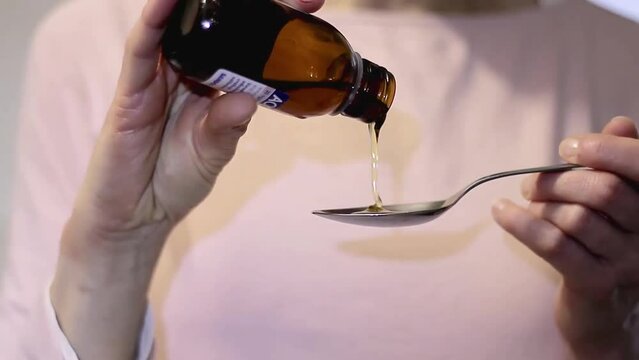 Healthcare pouring cough medicine in a teaspoon stock video stock footage