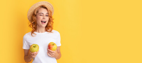 Summer girl hold apple. happy winking redhead woman in straw hat hold apple, lunch break. Woman...