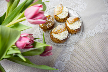 Shrove buns with pink tulips and lace tablecloth