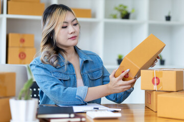 Woman working in online sales working with packing boxes preparing for shipping.