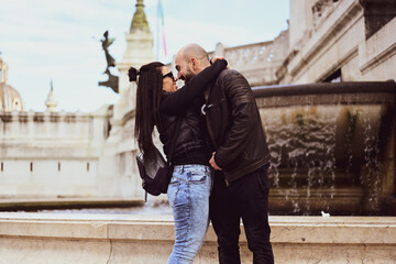 Happy  Tourists  couple traveling at Rome, Italy, poses in front of Altar of the Fatherland (Altare della Patria) and Piazza Venezia at, Rome, Italy