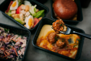 Containers with tasty takeout meals on dark background, top view. Food delivery