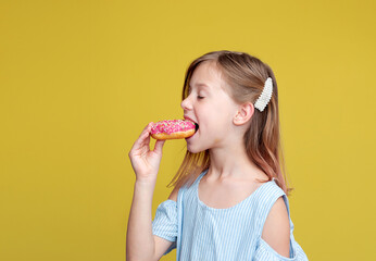 cute girl eating donut. Yellow background