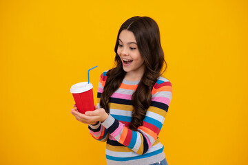 Teenage girl with take away cup of cappuccino coffee or tea. Child with takeaway cup on yellow background, morning drink beverage. Happy teenager, positive and smiling emotions of teen girl.
