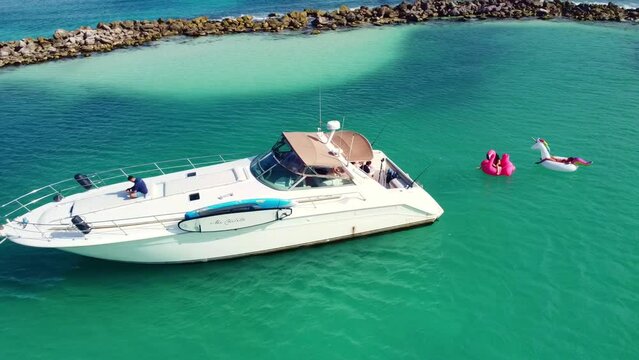 Aerial view of a white yacht in Puerto Aventuras in the the Mayan Riviera, M&eacute;xico while people relax on inflatables. 