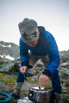 Hiker adjusting cooking utensil while preparing food at Olympic National Park