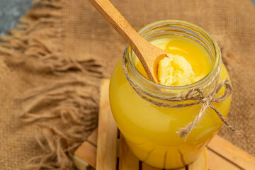 ghee oil. Ghee or clarified butter in jar on a wooden background. banner, menu, recipe place for text