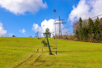 Ski lift at standstill due to lack of snow caused by climate change at the end of winter on a...