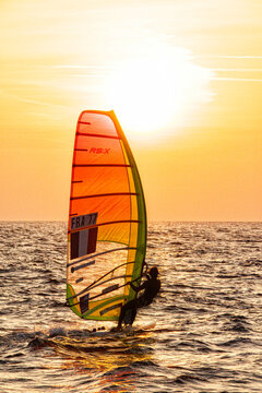 Pink Granite CoastPierre Le Coq riding his windsurf board during a sunset session on the "Cote de Granit Rose" ( Pink Granite Coast ), Tr&Atilde;&copy;gastel, Brittany, France.