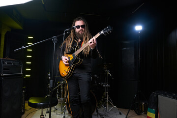 Fototapeta na wymiar Guitarist man plays an electric guitar Close-up at studio