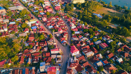 Aerial photo of the suburbs between green parks and morning sunshine