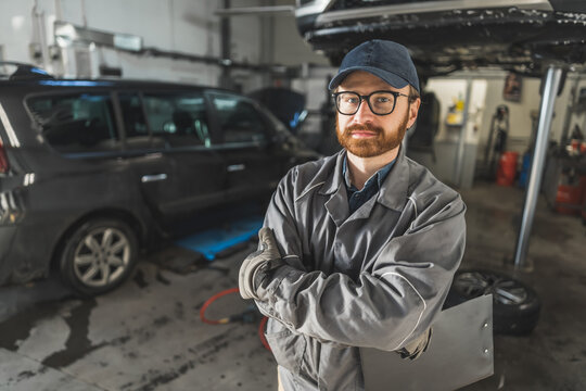 Portrait of a car mechanic with a black clipboard in an automobile repair shop. High quality photo
