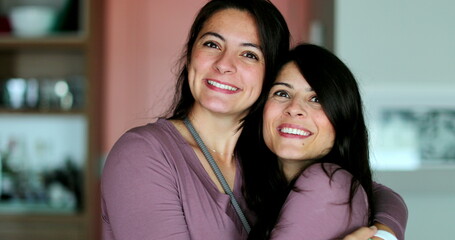 Sisters posing together portrait of two adult siblings smiling at camera