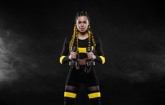 African american woman athlete. Download photo for fitness club advertising design. Woman workout with dumbbells in gym.