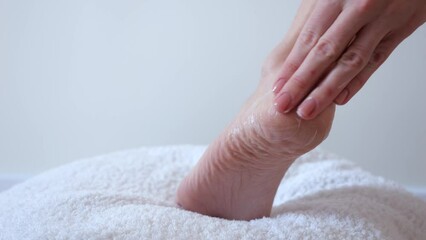 Woman applies cream to her heel