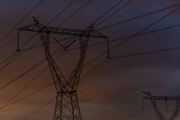 High voltage electrical tower with blue sky at sunset in the background