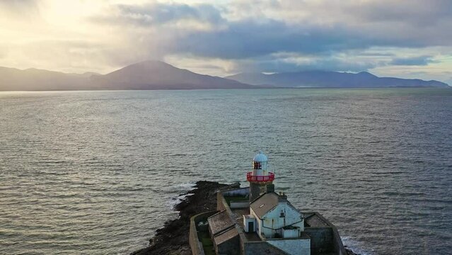 Aerial panorama view of the historic Fenit Lighthouse in Tralee Bay, beautiful clouds, sunset. High quality 4k footage