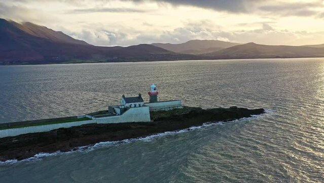 Aerial panorama view of the historic Fenit Lighthouse in Tralee Bay, beautiful clouds, sunset. High quality 4k footage