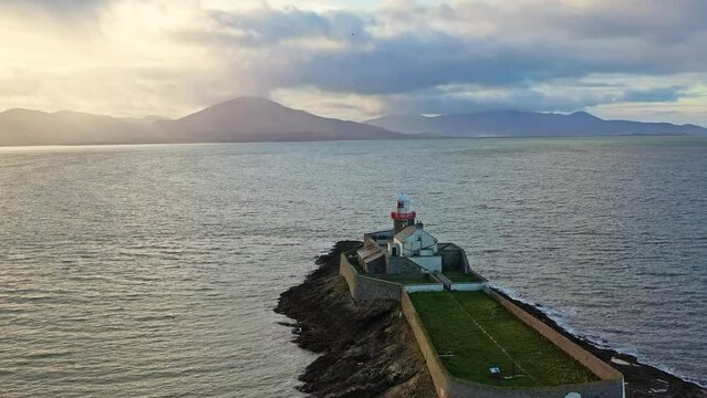 Aerial panorama view of the historic Fenit Lighthouse in Tralee Bay, beautiful clouds, sunset. High quality 4k footage