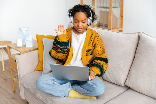 African american girl using laptop computer having video chat at home. Young woman having virtual meeting online chat video call conference sitting on couch. Work learning from home, remote teacher