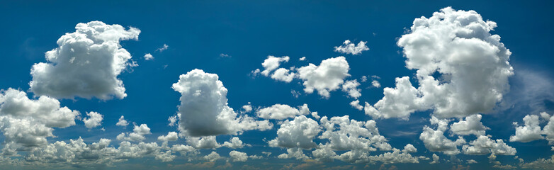 White puffy cumulus clouds on summer blue sky