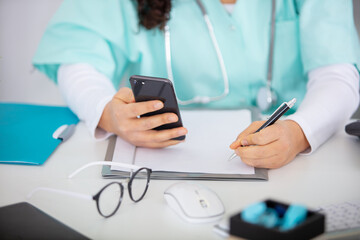 female doctor use a smartphone in her office