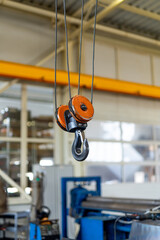 Metal factory construction hook for transportation. Crane hook inside factory building.