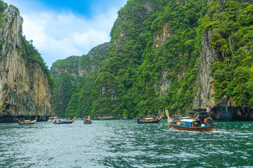 Fototapeta na wymiar Krabi, Thailand - May 12 2022 : Long-tailed boats are taking tourists travel to see the view of Phi Phi Leh Island in Phi Phi Islands National Park.