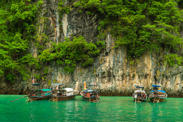 Krabi, Thailand - May 12 2022 : Long-tailed boats are taking tourists travel to see the view of Phi Phi Leh Island in Phi Phi Islands National Park.