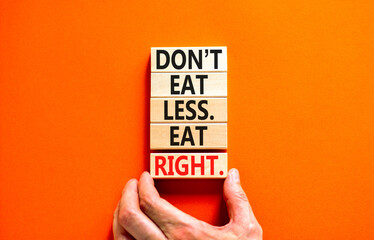 Eat less or right symbol. Concept words Do not eat less, eat right on wooden blocks. Beautiful orange table orange background. Doctor hand. Healthy lifestyle and eat less or right concept. Copy space.