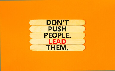 Push or lead people symbol. Concept words Do not push people lead them on wooden stick. Beautiful orange table orange background. Business Push or lead people concept. Copy space.