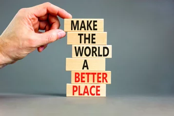 Fotobehang Make a better world symbol. Concept words Make the world a better place on wooden blocks. Beautiful grey table grey background. Businessman hand. Business make a better world concept. Copy space. © Dzmitry