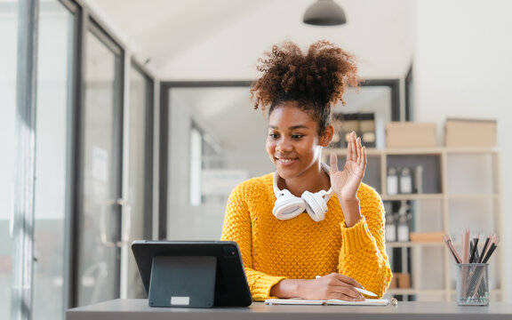 Pretty young african american student woman study online class in tablet video call zoom teacher learning english language experiment in knowledge-gathering from any location of their choice.
