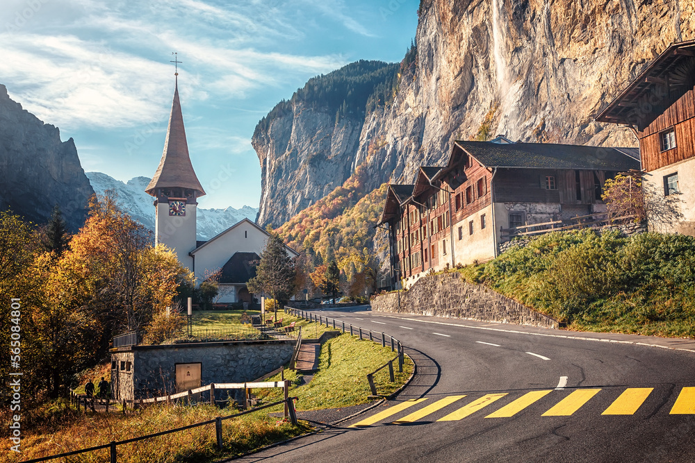 Fototapete Scenic sunny landscape in mountains. view on Mountain valley with highland village Lauterbrunnen, Staubbach waterfall. Popular travel dedtination. Creative image. Artistic style.