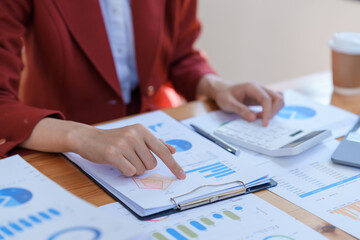 Businesswoman planning investment in a meeting. Close-up shot of business woman consultant pointing to graphs and analyzing financial reports balance sheet current account.