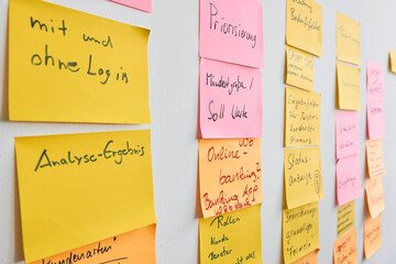picture of a scrum board. a physical wall with colored sticky notes, or post-its, on it.
