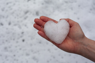Snieżka w kształcie serca na dłoni - obrazy, fototapety, plakaty