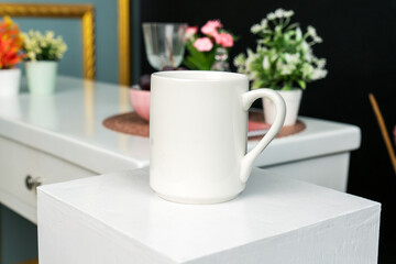 A white blank coffee mug on the top of a hand cloth with simple decorations arranged around it